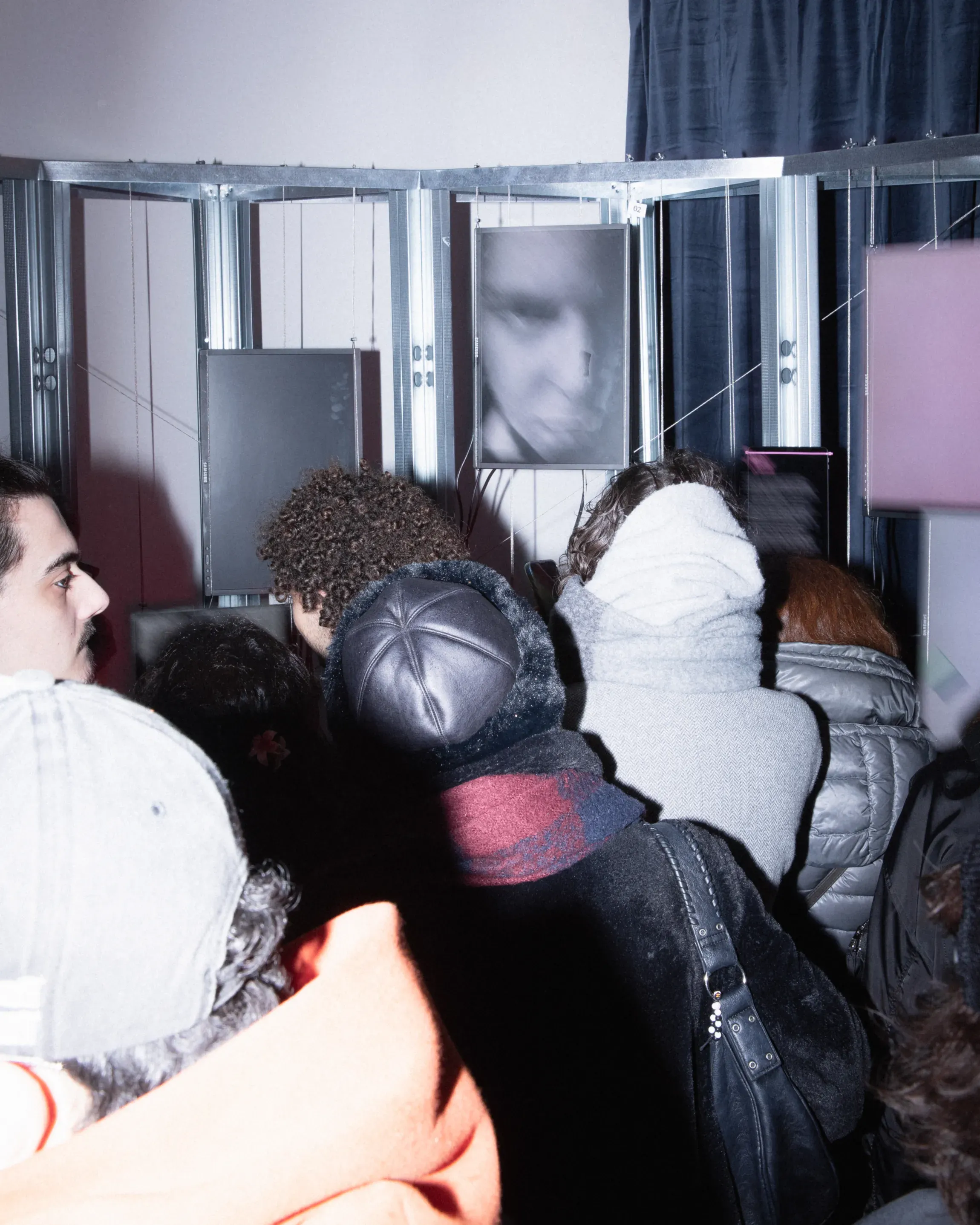 An Ecology of Beasts collective design exhibition at TXT Studio Milan, storefront installation with multiple vertical screens and pink lighting | Carlotta Bacchini