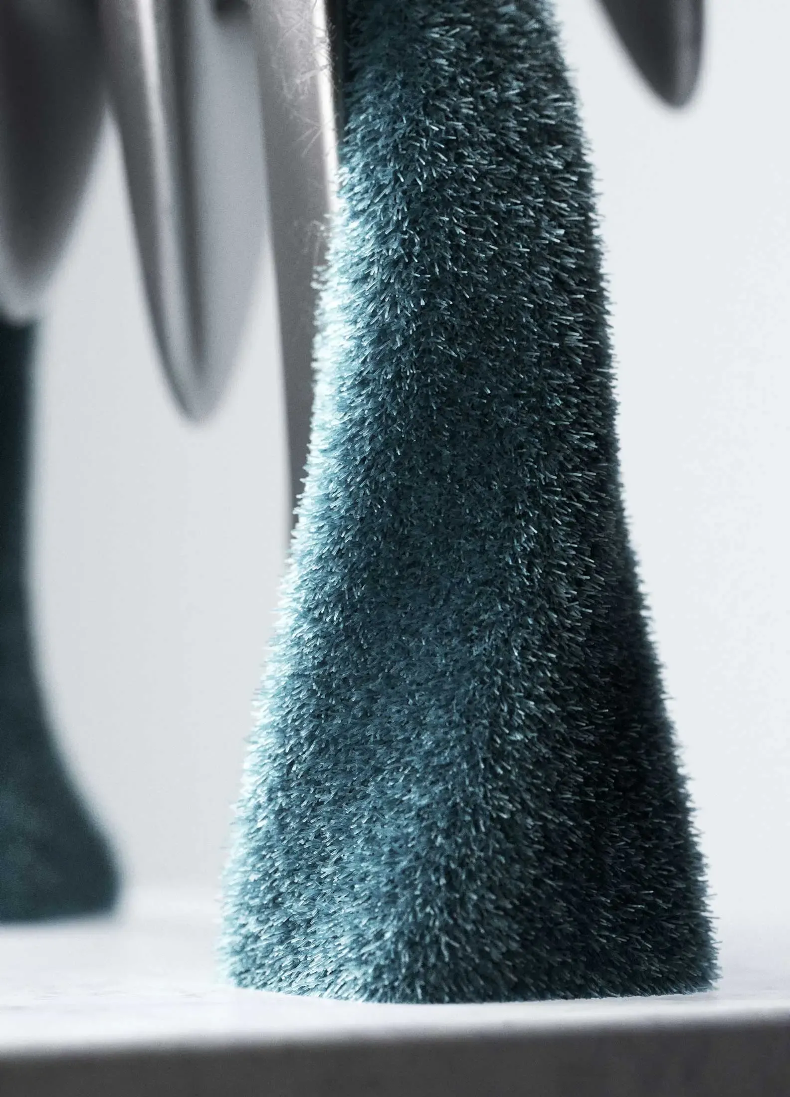Macro shot of the avatar’s soft blue fiber limbs, rendered with hyperreal synthetic texture and digital materiality.