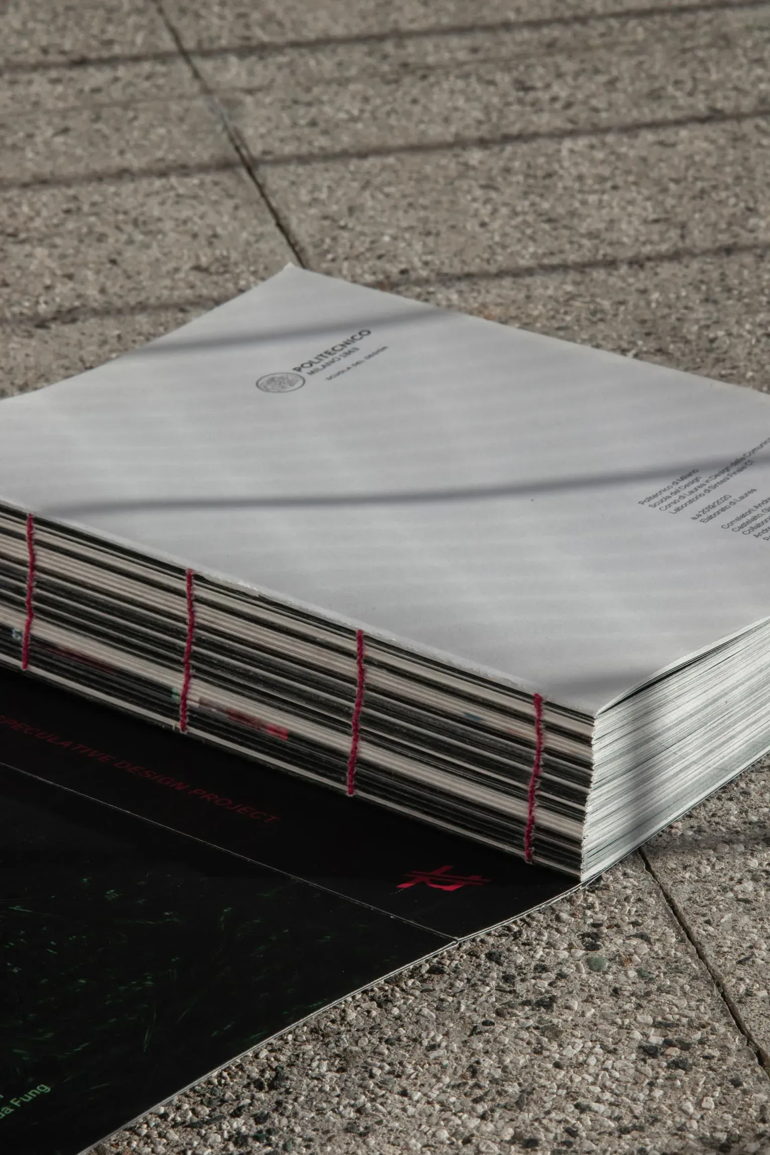 Back cover and exposed binding of the Micromort printed thesis, featuring Politecnico di Milano accreditation.